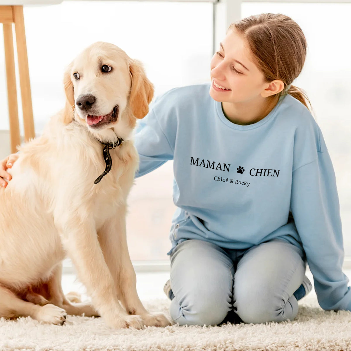 Fille à genoux près d'un golden retriever en pull bleu clair Maman Chien avec prénoms market_france