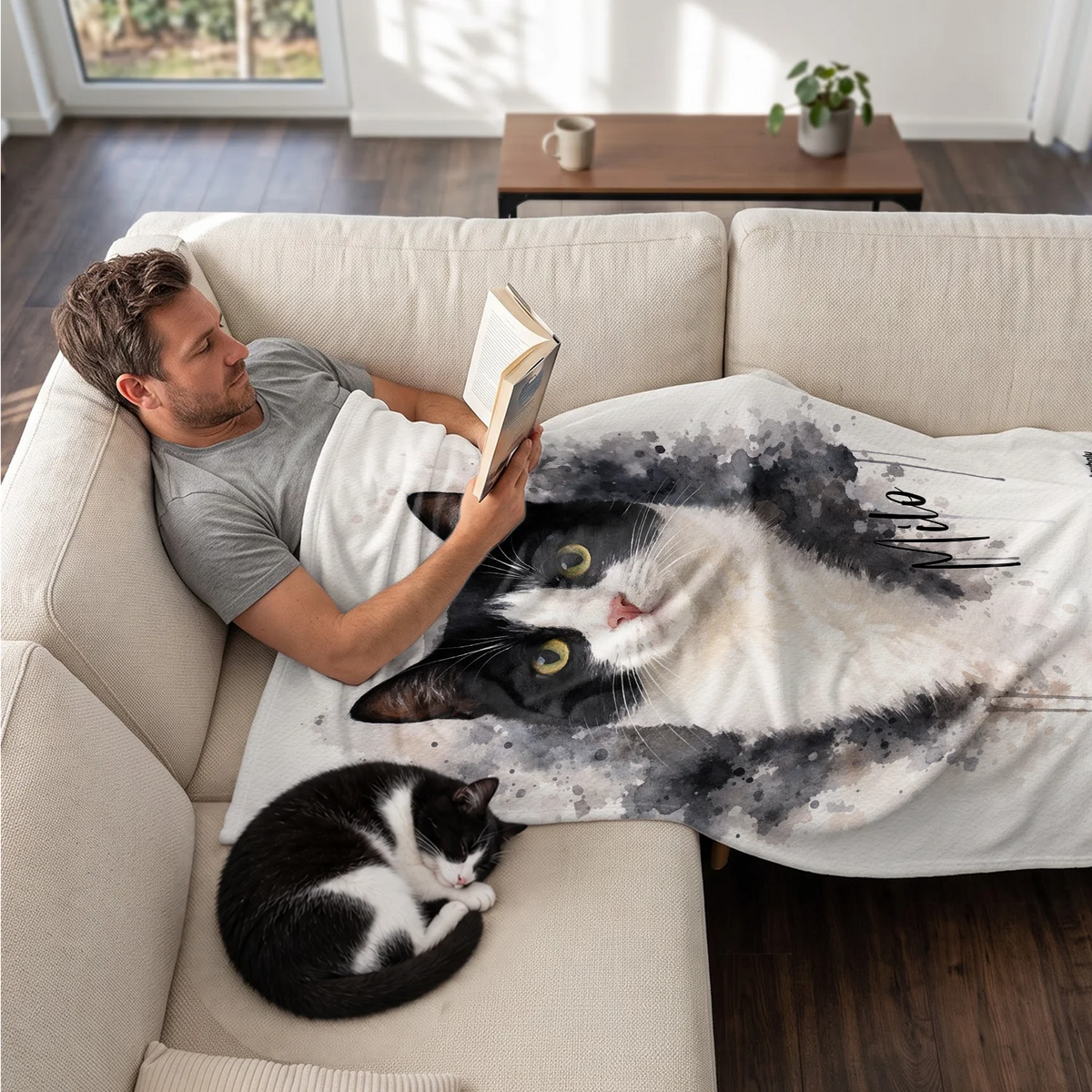 Homme lit sur le canapé sous le plaid chat aquarelle, son chat dort à côté market_france